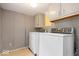 Functional laundry room with classic washer and dryer and neutral checkered wallpaper at 1497 Clinton St, Noblesville, IN 46060