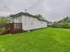 Expansive backyard featuring lush green lawn and wood deck, perfect for outdoor living at 1520 E Kirk St, Muncie, IN 47303