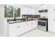 Bright kitchen features white cabinets, stainless steel appliances, and vinyl floors at 1520 E Kirk St, Muncie, IN 47303