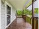 Covered front porch featuring wood flooring and railings, creating a welcoming entrance to the home at 1520 E Kirk St, Muncie, IN 47303
