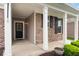 Covered front porch featuring white columns, brick accents, and an inviting entrance with sidelights at 16573 Cava Dr, Fishers, IN 46037