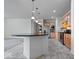 Open-concept kitchen with a dark countertop island, modern appliances, and tile flooring throughout at 16573 Cava Dr, Fishers, IN 46037