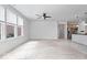 Spacious living room featuring large windows and ceiling fan next to kitchen at 16573 Cava Dr, Fishers, IN 46037