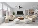 Staged open concept living room featuring large windows, ceiling fan and modern furniture at 16573 Cava Dr, Fishers, IN 46037
