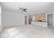 Open-concept living room with a ceiling fan, access to kitchen, and large windows at 16573 Cava Dr, Fishers, IN 46037