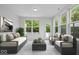 Staged living room featuring large windows overlooking backyard, complete with modern furniture at 16573 Cava Dr, Fishers, IN 46037