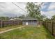 Backyard featuring a well-maintained lawn and a quaint, detached gray garage at 1661 S Talbott St, Indianapolis, IN 46225