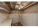 Unfinished basement with painted walls, exposed ceiling beams, and a simple storage shelf at 1661 S Talbott St, Indianapolis, IN 46225