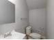 Clean, neutral bathroom with a white toilet, sink, a large mirror, and updated fixtures at 1661 S Talbott St, Indianapolis, IN 46225