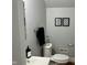 Well-lit bathroom featuring a toilet, sink, vanity, mirror, and modern hardware at 1661 S Talbott St, Indianapolis, IN 46225