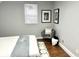 Neutral-toned bedroom with wood flooring, minimalist decor, and comfortable accent chair at 1661 S Talbott St, Indianapolis, IN 46225