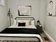 Stylized bedroom featuring unique wall art, a black metal bed frame, and complementary neutral tones at 1661 S Talbott St, Indianapolis, IN 46225