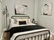 Well-lit bedroom with neutral-toned walls, a black metal bed frame, and modern decor at 1661 S Talbott St, Indianapolis, IN 46225