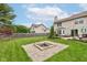 Spacious backyard with a stone fire pit and lush green lawn at 18915 Fairfield Blvd, Noblesville, IN 46060