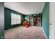 Green bedroom with a leather chair, bookshelves, and a window that lets in natural light at 18915 Fairfield Blvd, Noblesville, IN 46060