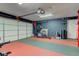 Functional garage space with exercise equipment, textured flooring, and convenient garage door access at 18915 Fairfield Blvd, Noblesville, IN 46060