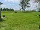 Sprawling green backyard with a vibrant lawn, mature trees, and distant views of the surrounding landscape at 1925 W State Road 32, Lebanon, IN 46052