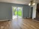 Living room with hardwood floors, brick fireplace, ceiling fan, and a sliding door with a view at 1925 W State Road 32, Lebanon, IN 46052