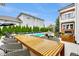 Outdoor dining area with ample seating and a view of the pool and landscaped yard at 2037 Stanhope St, Carmel, IN 46032