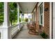 Relaxing front porch with rocking chairs, offering a cozy outdoor space with brick walls and white columns at 2037 Stanhope St, Carmel, IN 46032