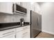 Modern kitchen features stainless steel refrigerator, microwave, and white cabinets with sleek hardware at 2037 Stanhope St, Carmel, IN 46032