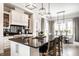 Spacious kitchen featuring a large island with seating, modern lighting, and stainless steel appliances at 2037 Stanhope St, Carmel, IN 46032