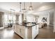 Open concept kitchen and living area with an island featuring dark countertops and pendant lighting at 2037 Stanhope St, Carmel, IN 46032