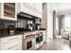 Gourmet kitchen showcasing a Wolf range, black countertops, and white cabinets with glass door uppers at 2037 Stanhope St, Carmel, IN 46032