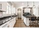 Spacious kitchen boasts white cabinetry, stainless appliances, and dark granite countertops with a kitchen island at 2037 Stanhope St, Carmel, IN 46032