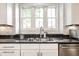 Close-up on the kitchen sink featuring granite countertops, modern faucet, and stainless steel dishwasher at 2037 Stanhope St, Carmel, IN 46032