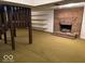 Basement showcasing a brick fireplace, shelving, and yellow carpeting at 310 S Shady Ln, Muncie, IN 47304