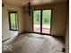 Dining room with backyard access to a deck, brick accent wall, and light fixture at 310 S Shady Ln, Muncie, IN 47304