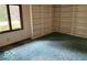 Living room featuring built-in shelving, a window, and green carpeting at 310 S Shady Ln, Muncie, IN 47304