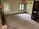 Neutral living room featuring two large windows, a fireplace, and access to other rooms at 310 S Shady Ln, Muncie, IN 47304