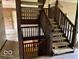 Two-story staircase featuring carpeted steps and a wooden railing at 310 S Shady Ln, Muncie, IN 47304