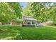 Exterior rear view of home showing the well-maintained lawn, large windows, and patio area at 3333 Melbourne S Rd, Indianapolis, IN 46228