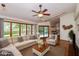 Open living room with large windows, ceiling fan and a view of the kitchen and backyard at 3333 Melbourne S Rd, Indianapolis, IN 46228