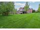 Spacious backyard with vibrant green grass and mature trees at 3744 Abney Point Dr, Carmel, IN 46077