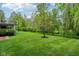 A backyard with a lush green lawn and a variety of trees and shrubs surrounding the property at 3744 Abney Point Dr, Carmel, IN 46077