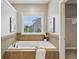 Elegant bathtub with tile surround and natural light at 3744 Abney Point Dr, Carmel, IN 46077