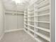 Spacious walk-in closet with custom shelving, rod for hanging clothes, and carpeted floor at 3744 Abney Point Dr, Carmel, IN 46077