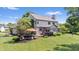 Back exterior view of a two-story home with a deck and patio area and lush green lawn at 3823 Brigade Cir, Carmel, IN 46032