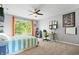 Bedroom with large window, desk, and sporty decor; ceiling fan at 3823 Brigade Cir, Carmel, IN 46032