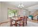 Bright dining area with large window offering verdant views and classic chandelier at 3823 Brigade Cir, Carmel, IN 46032