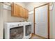 Bright laundry room with white washer and dryer units, and woodgrain cabinetry at 3823 Brigade Cir, Carmel, IN 46032