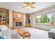 Comfortable living room featuring a brick fireplace, built-in shelving, and a large window at 3823 Brigade Cir, Carmel, IN 46032