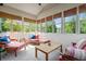 Bright sunroom with abundant windows and comfortable seating with colorful accents at 3823 Brigade Cir, Carmel, IN 46032