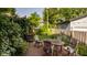 Charming backyard with a brick patio, mature trees, and a view of the home's detached garage at 3840 N Washington Blvd, Indianapolis, IN 46205