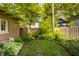 Beautiful backyard featuring a vibrant lawn, garden, stone pathway, and privacy fence with mature trees at 3840 N Washington Blvd, Indianapolis, IN 46205