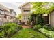 Charming backyard featuring lush garden beds, a brick patio, and a home with beautiful architectural details at 3840 N Washington Blvd, Indianapolis, IN 46205